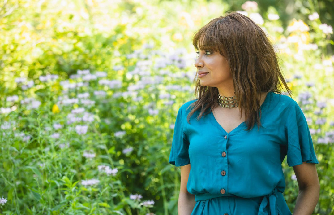 Standing in a park surrounded by flowers and greenery
