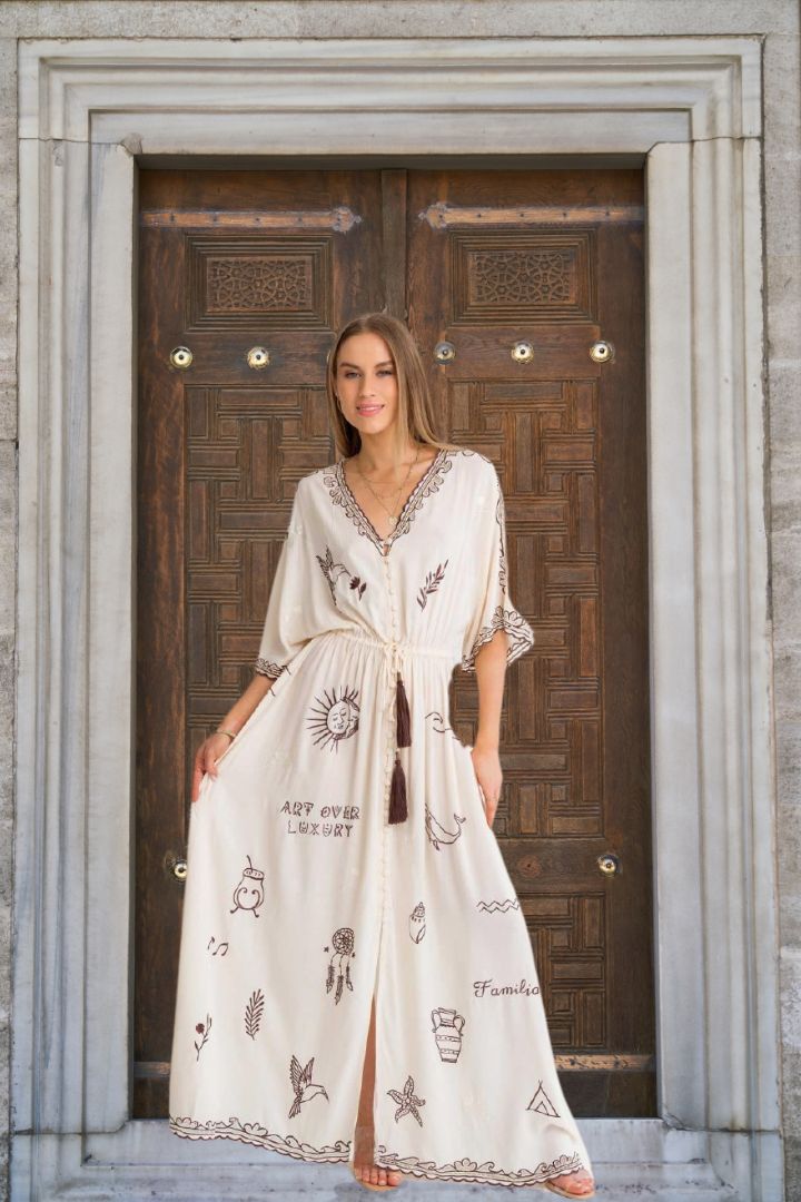 Woman in a white embroidered dress standing in front of a wooden door.