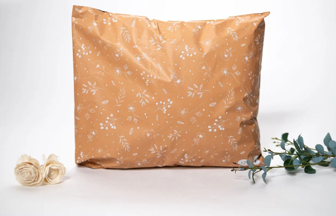 Beige shipping mailer with a flower and leaves on a white background