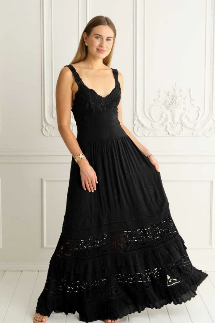 woman in black embroidered dress in white room