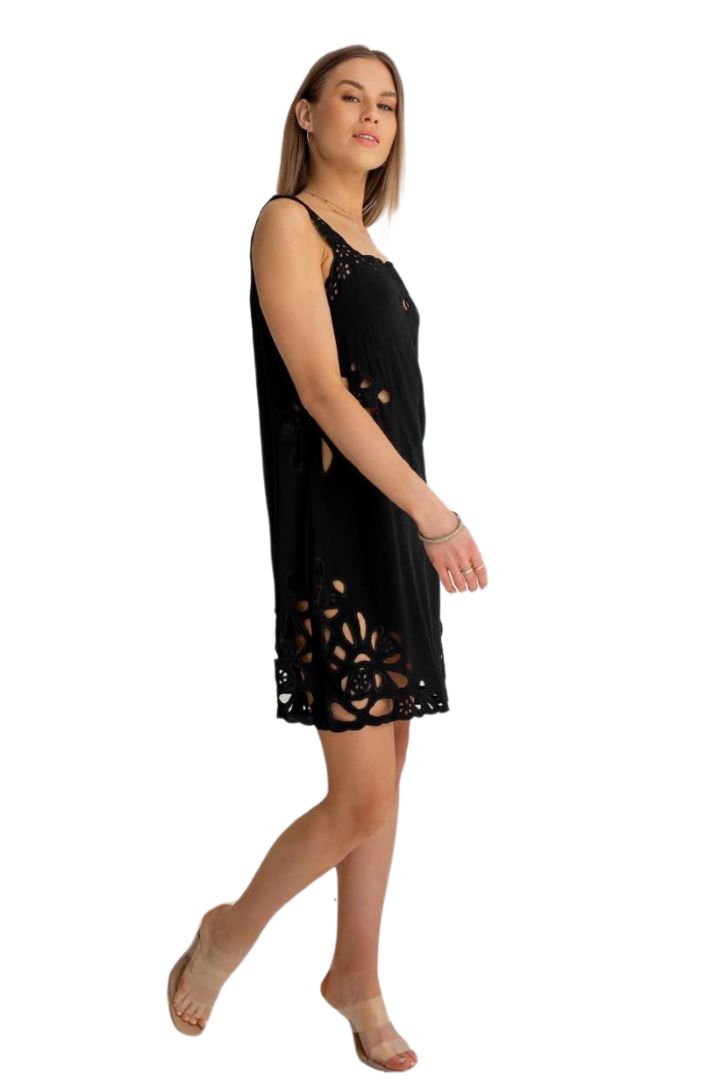 Woman wearing a black sleeveless dress with cut-out details on a white background