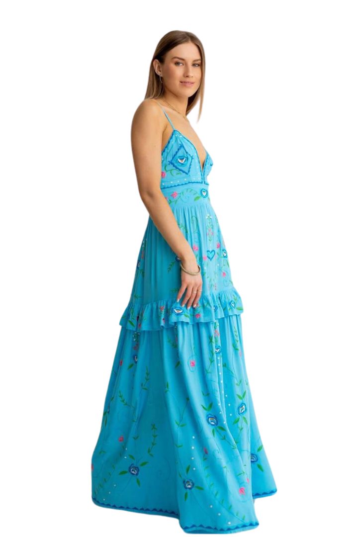 Woman wearing a blue dress with floral patterns on a white background