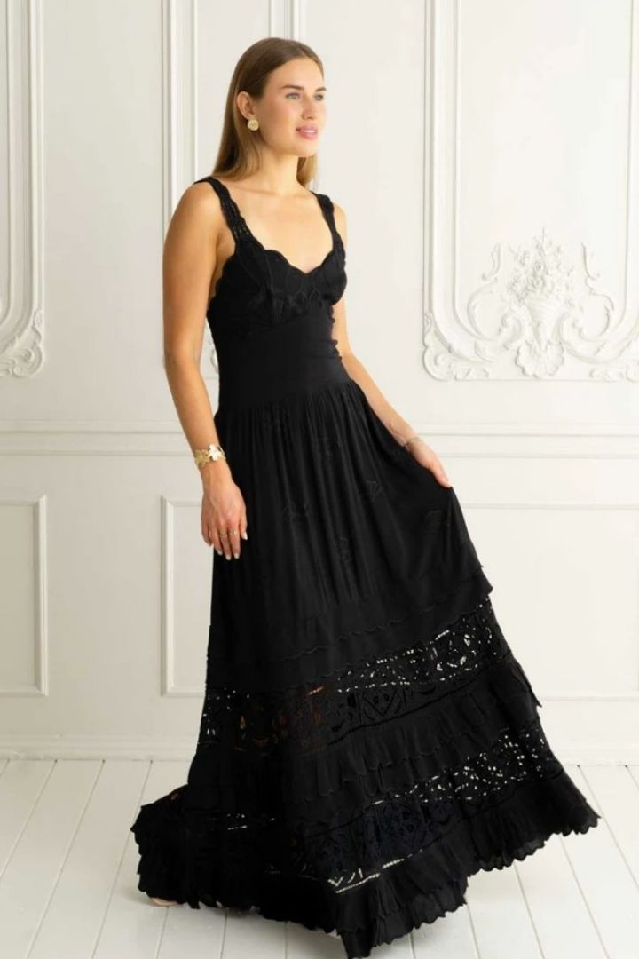 woman in black embroidered dress in white room