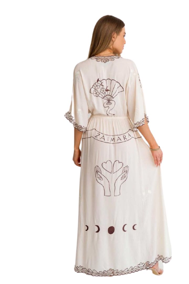Woman wearing a long embroidered dress on a white background