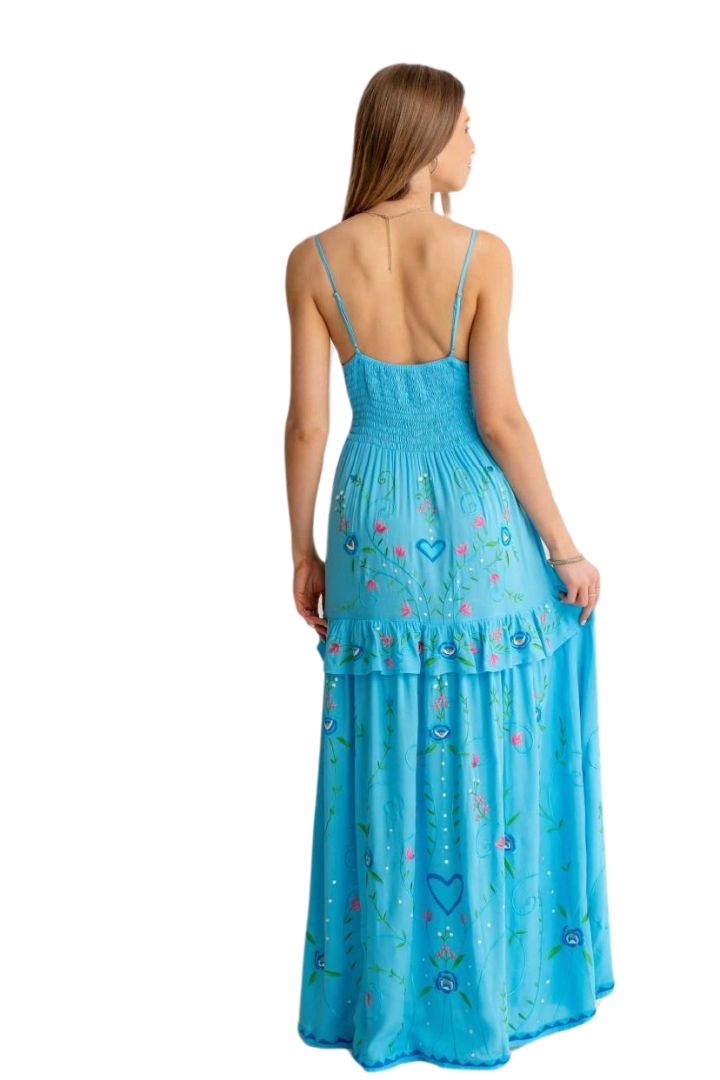 Woman wearing a blue dress with floral patterns on a white background