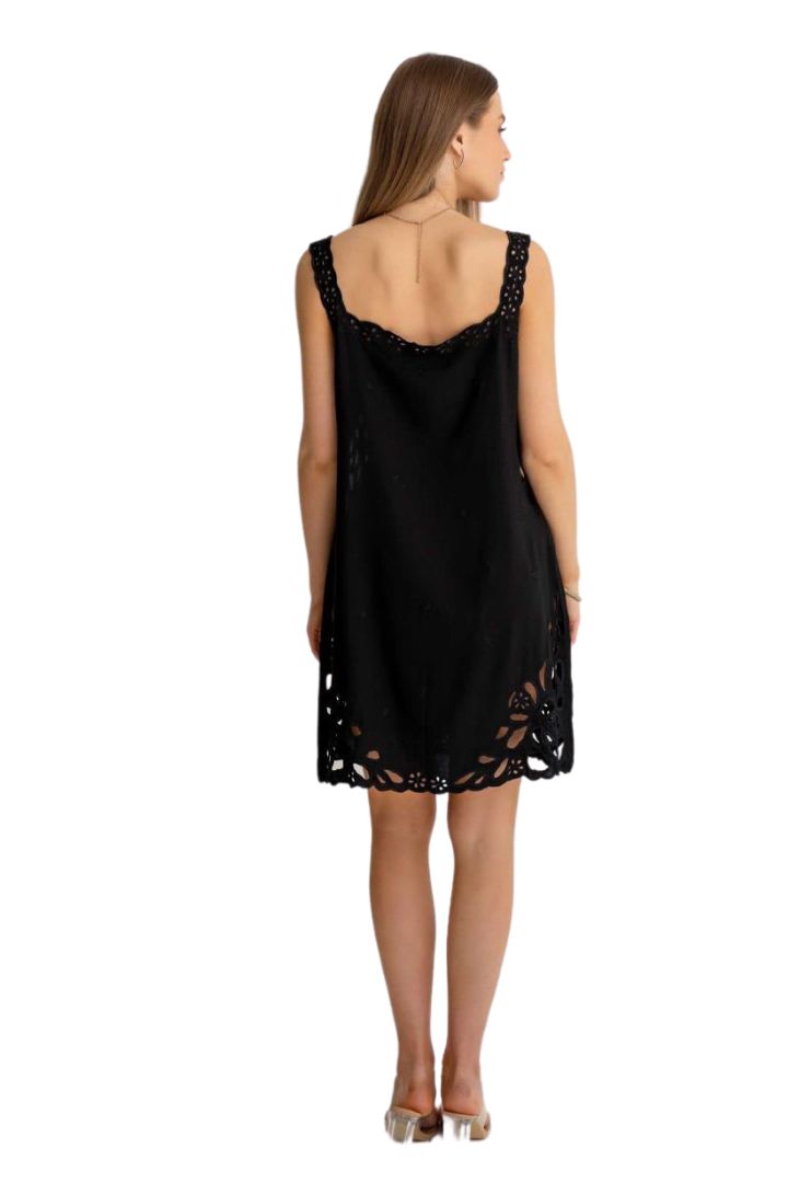 Woman wearing a black slip dress with lace details on a white background
