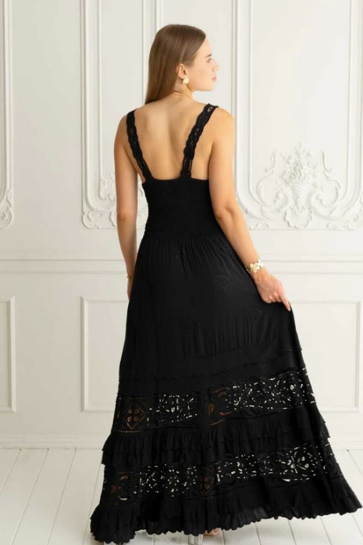 woman in black embroidered dress in white room back view of dress